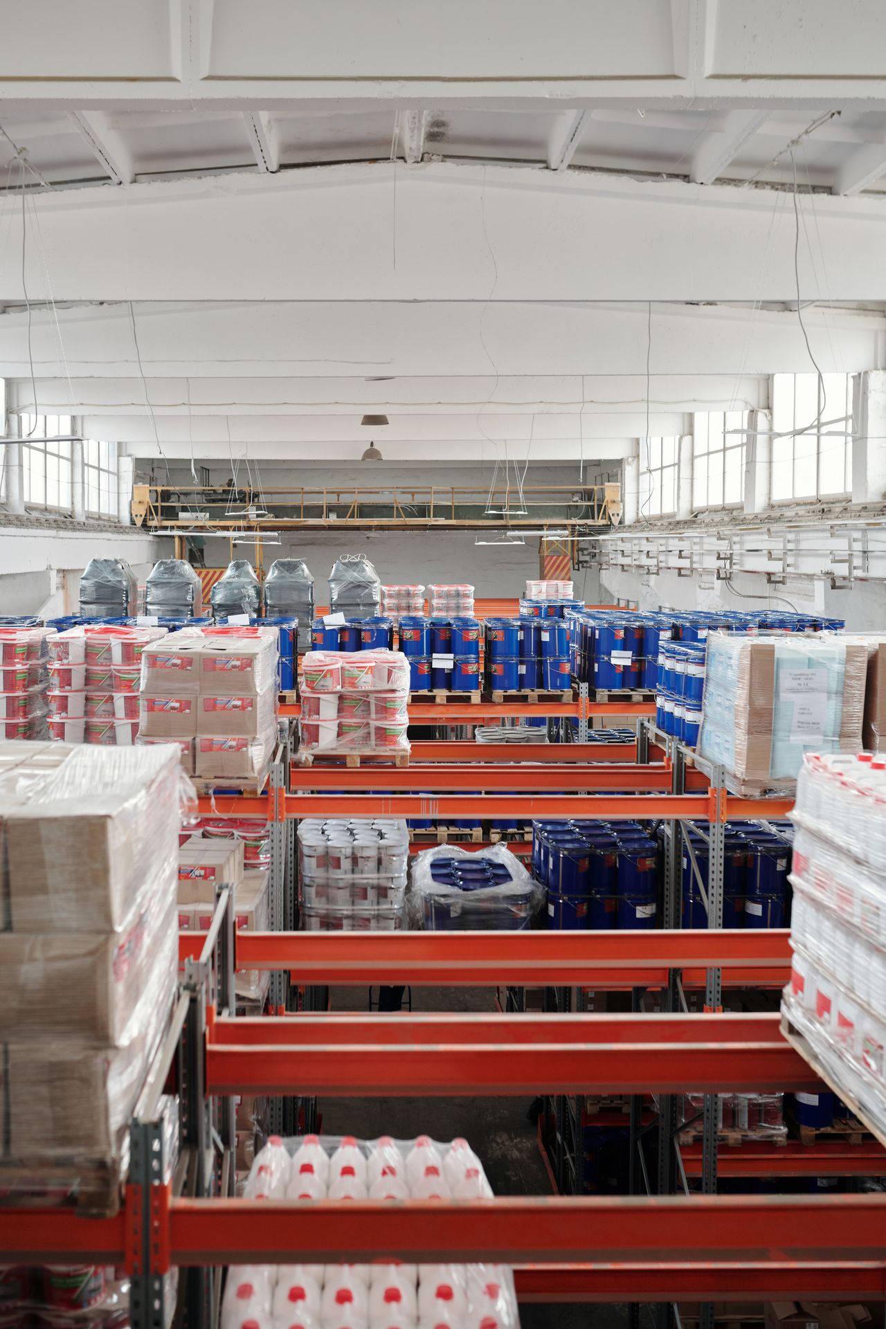 Pallets and cartons on shelving in a warehouse.