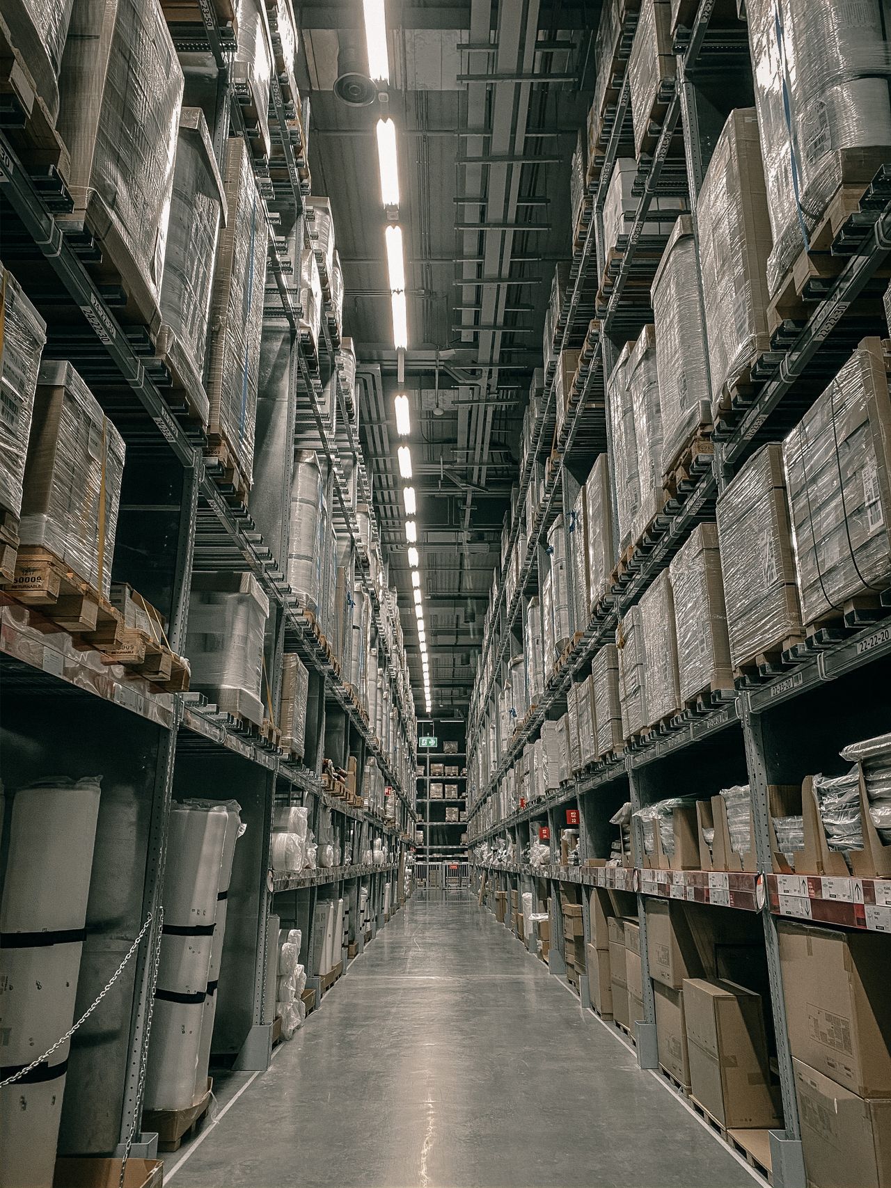 A long aisle in a warehouse with high shelving.