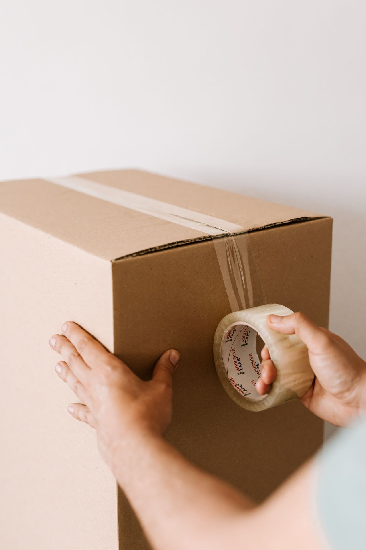 A cardboard box being sealed with tape before dispatch.